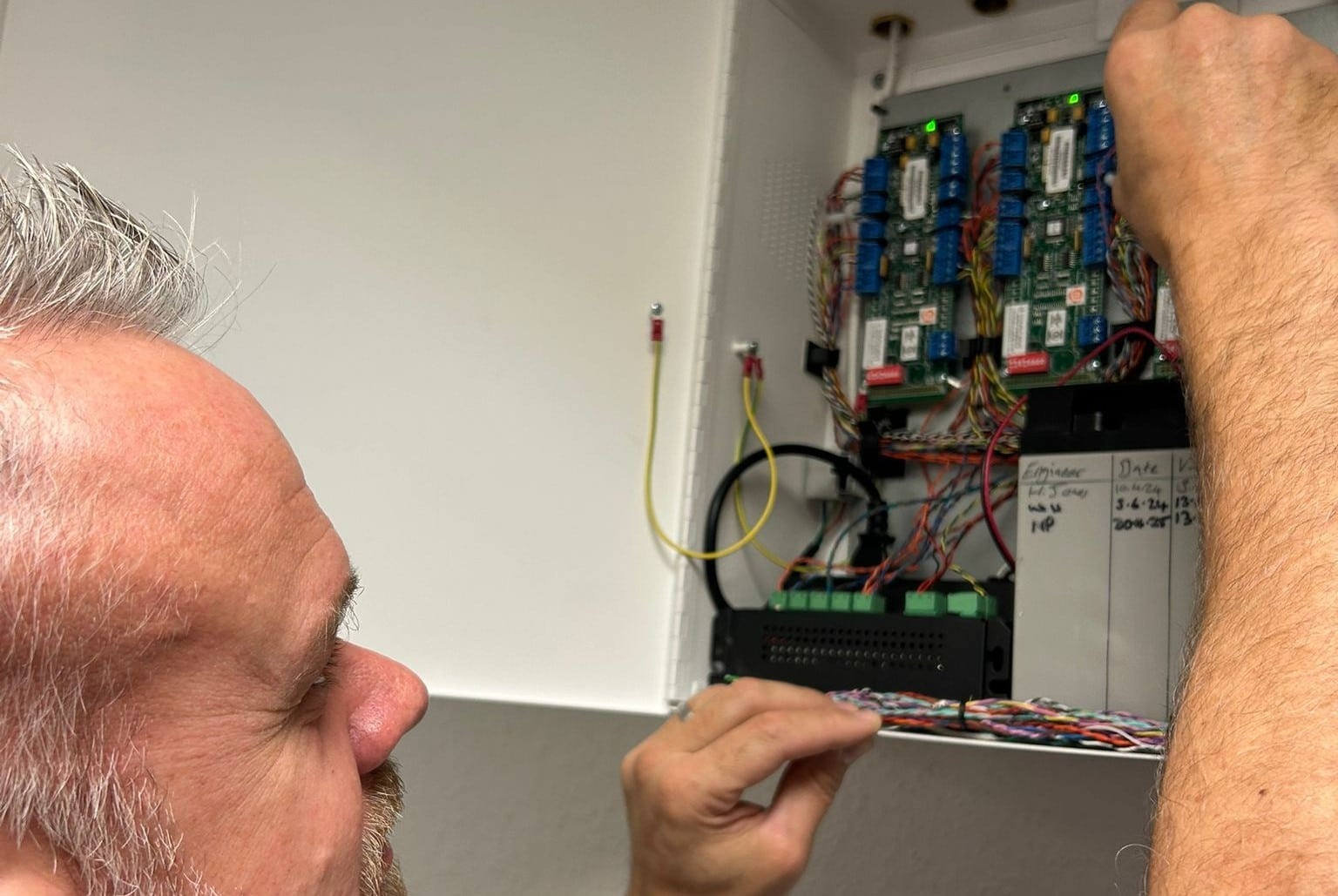 Careers - How can my career progress Man working on wiring inside an electrical control panel.
