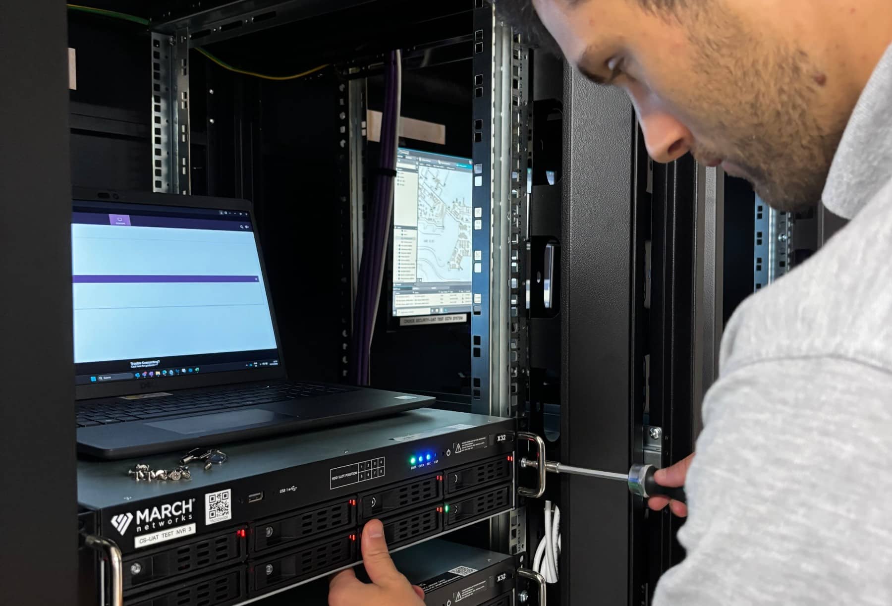 Careers - What would my role look like Man working with server equipment in a data center, using a screwdriver and a laptop.