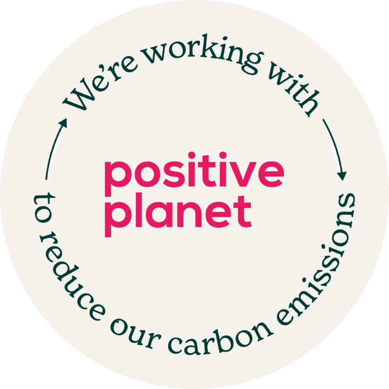 Circular logo with text: "positive planet" and "We're working with to reduce our carbon emissions."